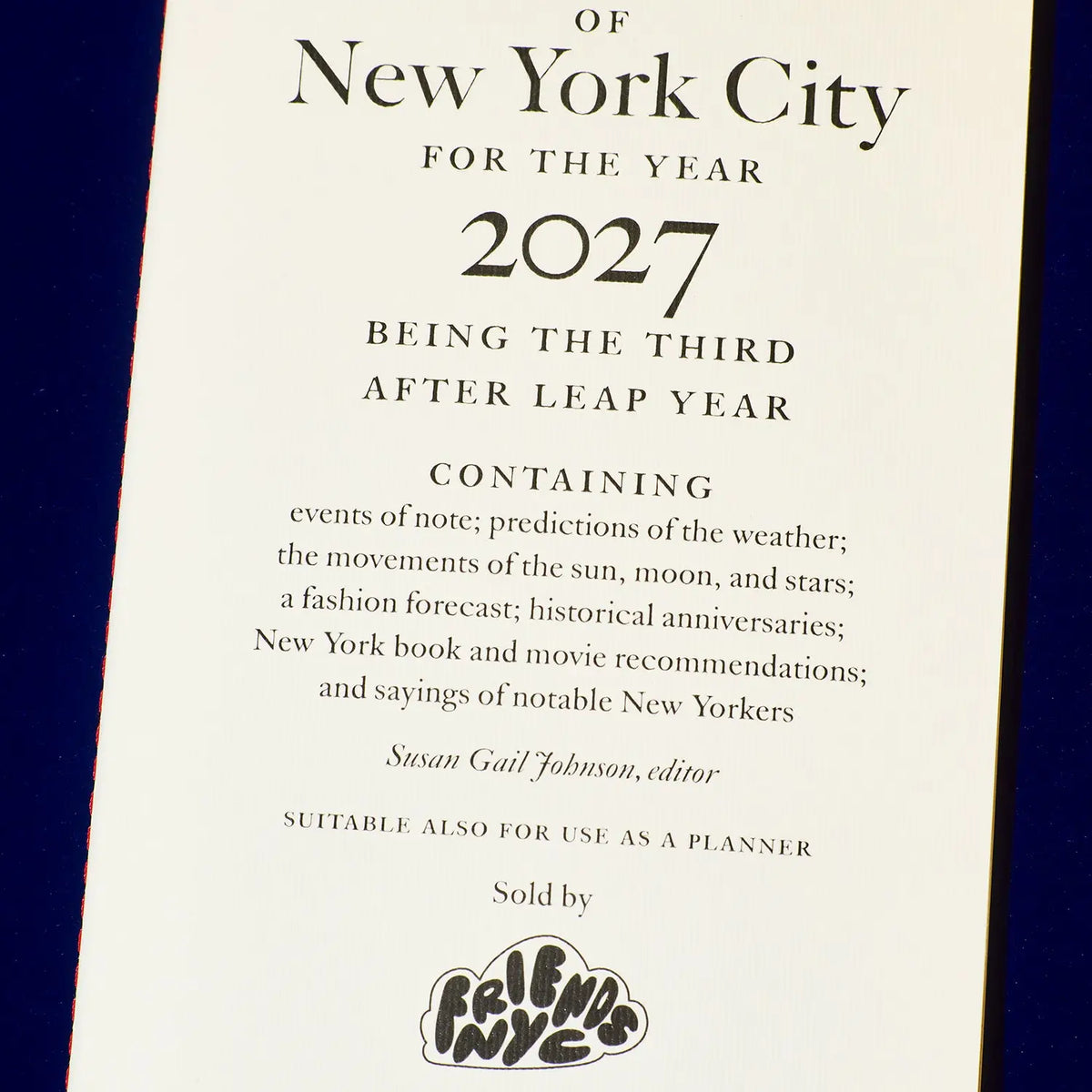 A printed cover or insert for 'Of New York City for the year 2027' with decorative text and a 'Friends NYC' logo at the bottom, photographed against a dark blue background.