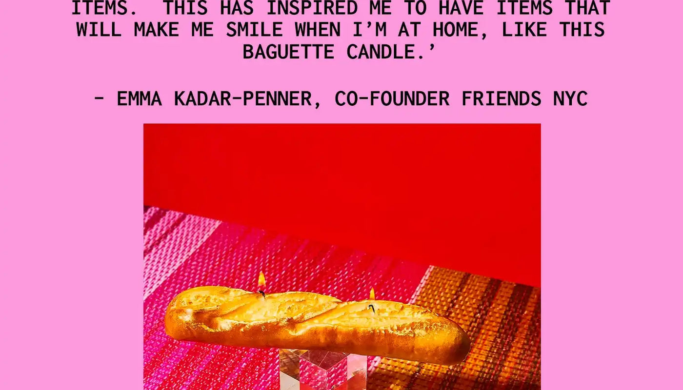 A baguette-shaped candle sitting on a clear acrylic holder.