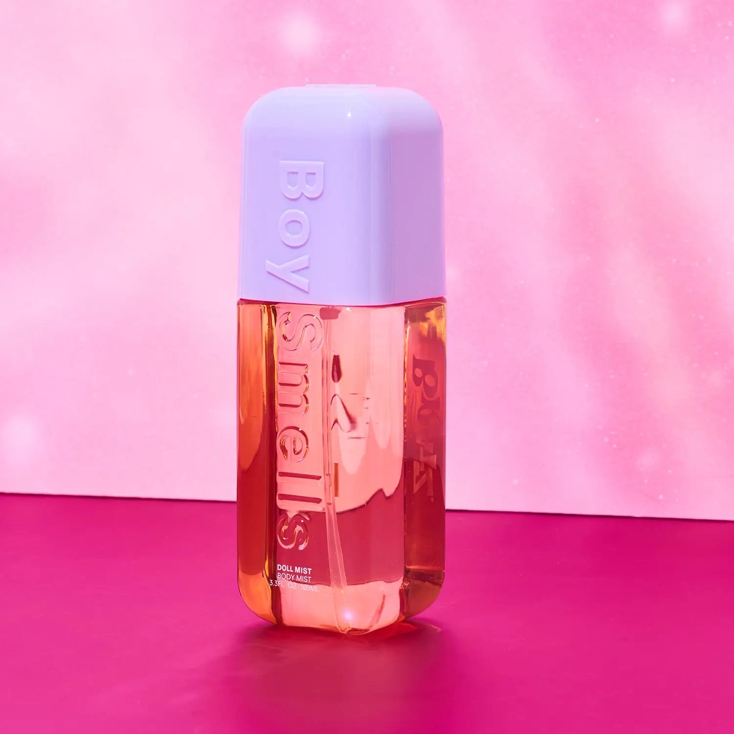Perfume bottle with a light purple cap on a pink background