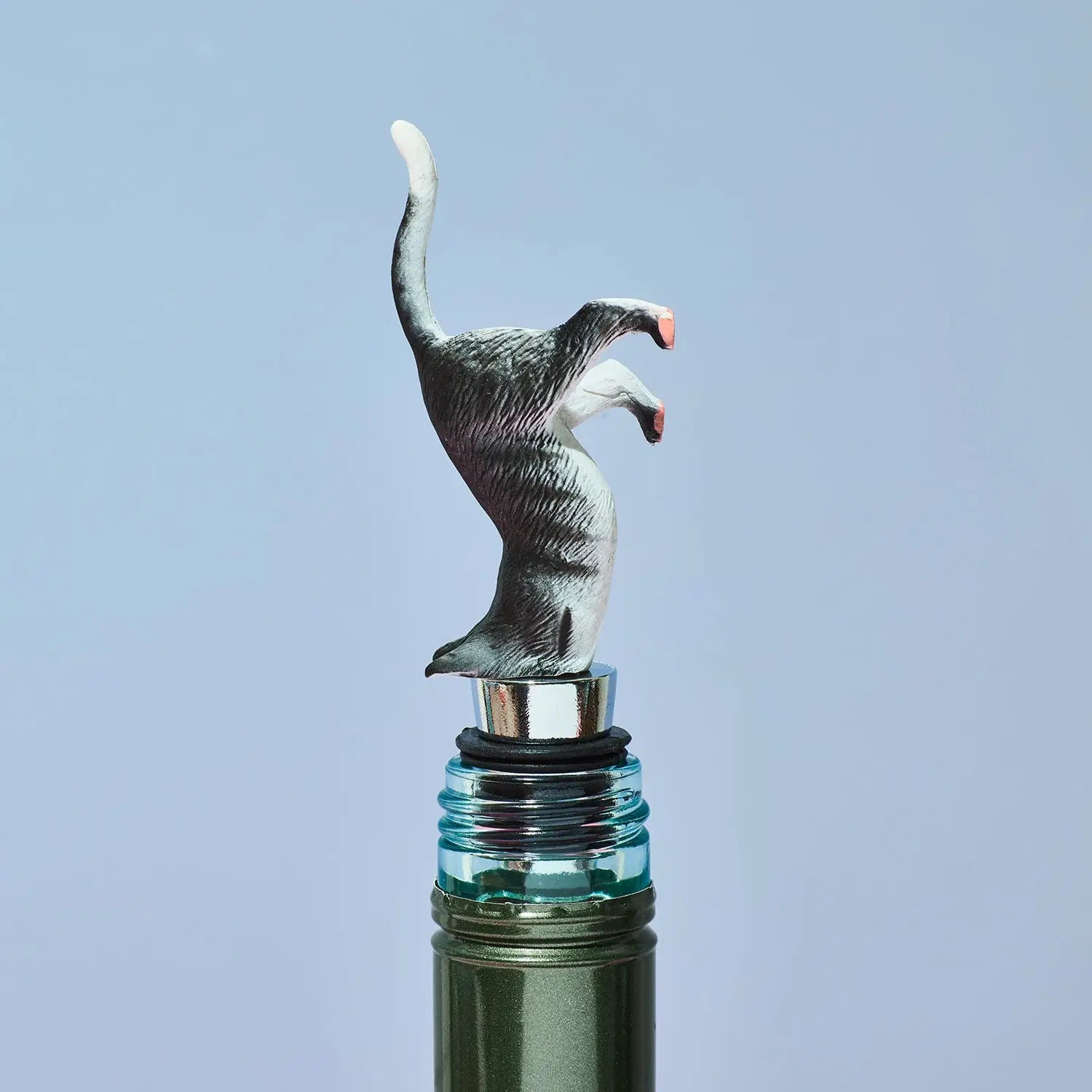 Wine bottle stopper shaped like a cat on a light blue background