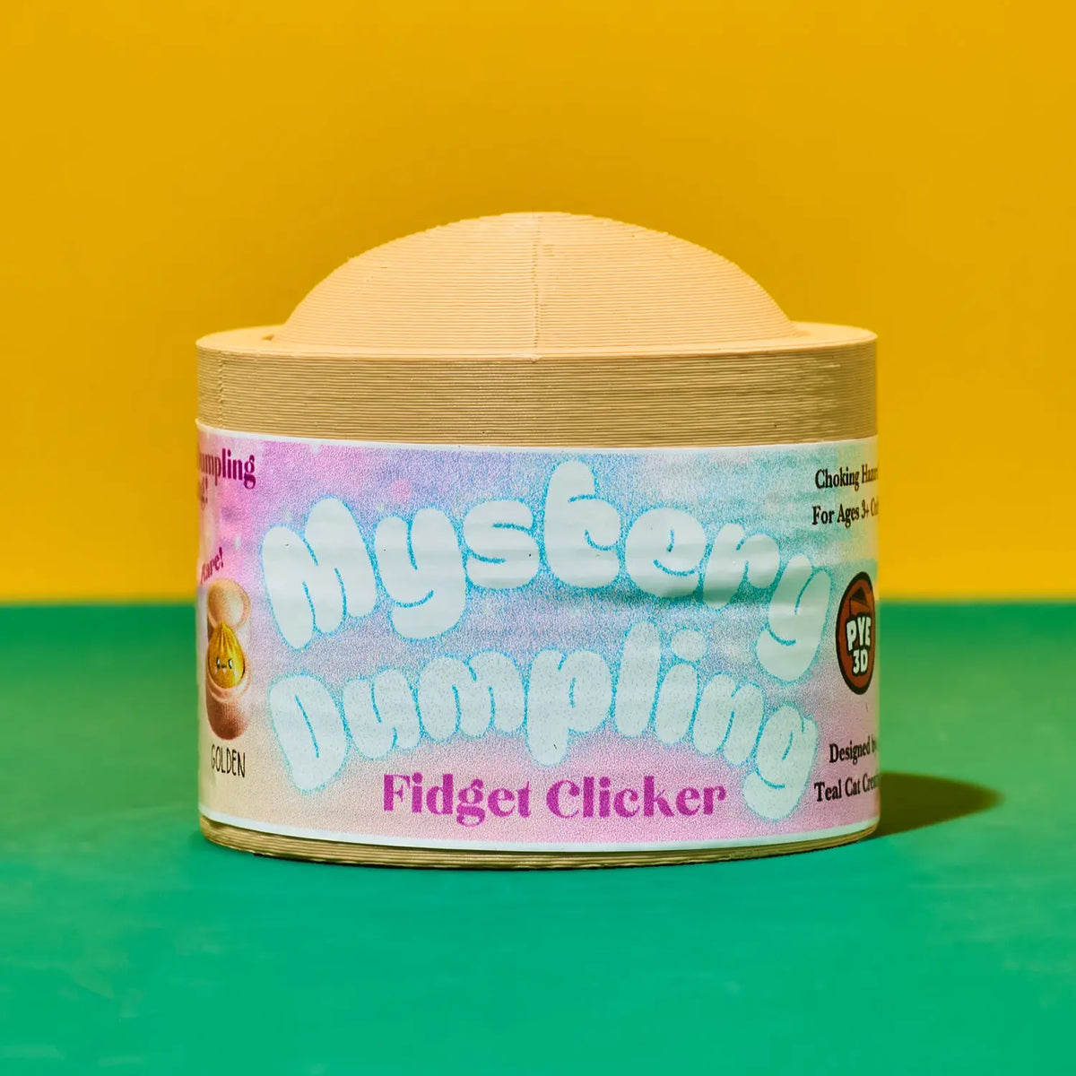 A wooden fidget clicker toy labeled 'Mystery Dumpling Fidget Clicker' sits centered on a split yellow and green background.