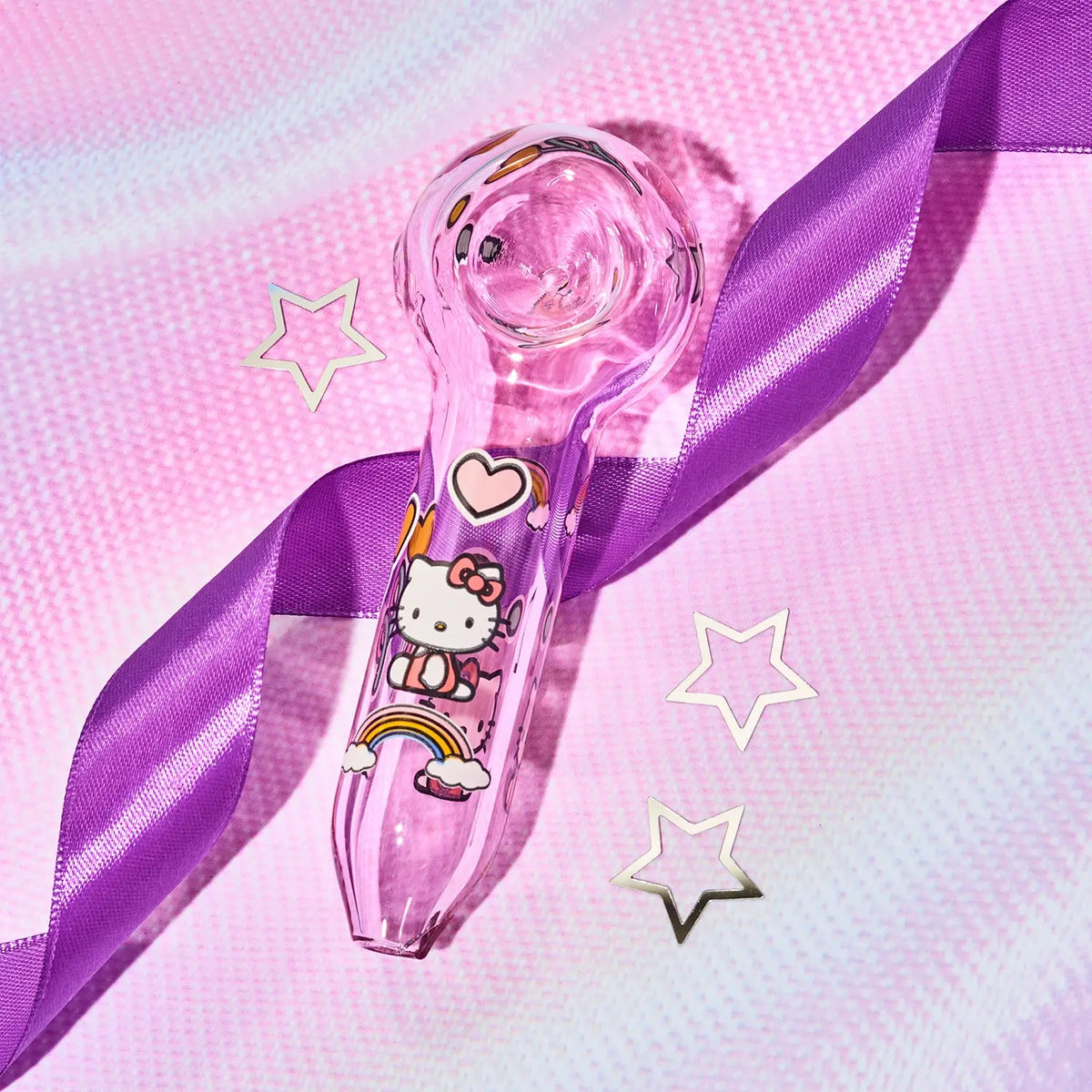 A pink transparent glass hand pipe decorated with Hello Kitty illustrations, wrapped with a purple satin ribbon on a pink textured background with star-shaped accents.