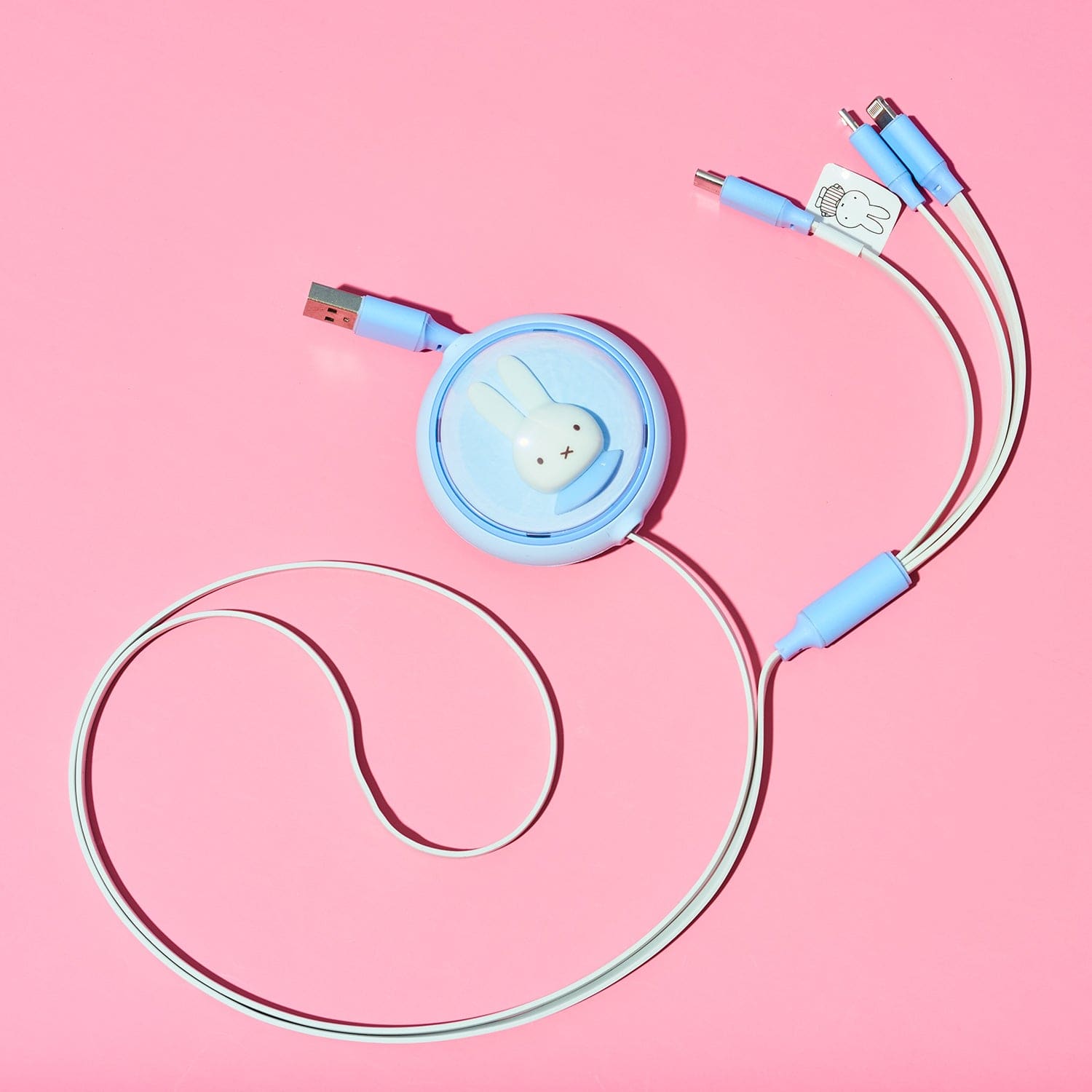Multi-device charging cable with a cute animal-shaped reel on a pink background