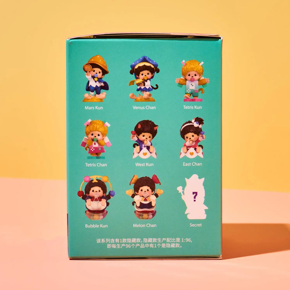 A teal collectible blind box shown from the back, featuring illustrations of nine cartoon girl characters labeled Mans Kun, Venus Chan, Tetris Kun, Tetris Chan, Wei Kun, East Chan, Bubble Kun, Melon Chan, and Secret, on a warm yellow and peach background.