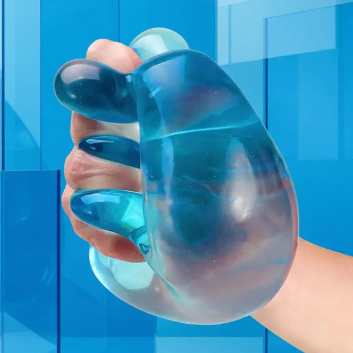 Hand holding a blue and clear gel massager against a light blue background
