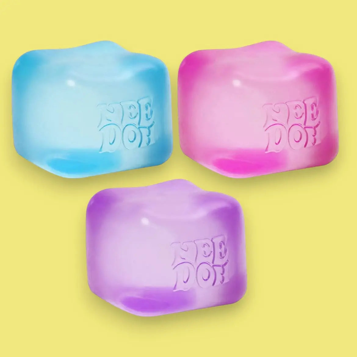 Three colorful ice cube-shaped objects with 'Nee Doh' branding on a yellow background