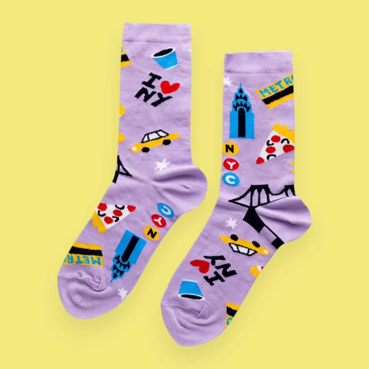 Pair of purple socks with colorful designs on a yellow background