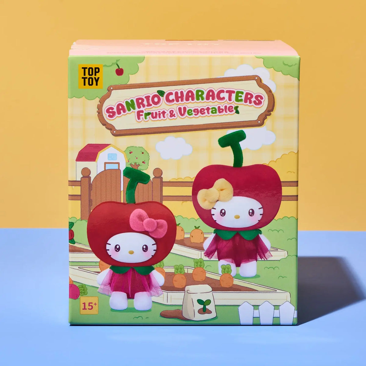 A boxed blind box toy for TOP TOY Sanrio Characters Fruit & Vegetable, featuring Hello Kitty characters dressed as red fruits on the front of the packaging, set against a split yellow and blue background.