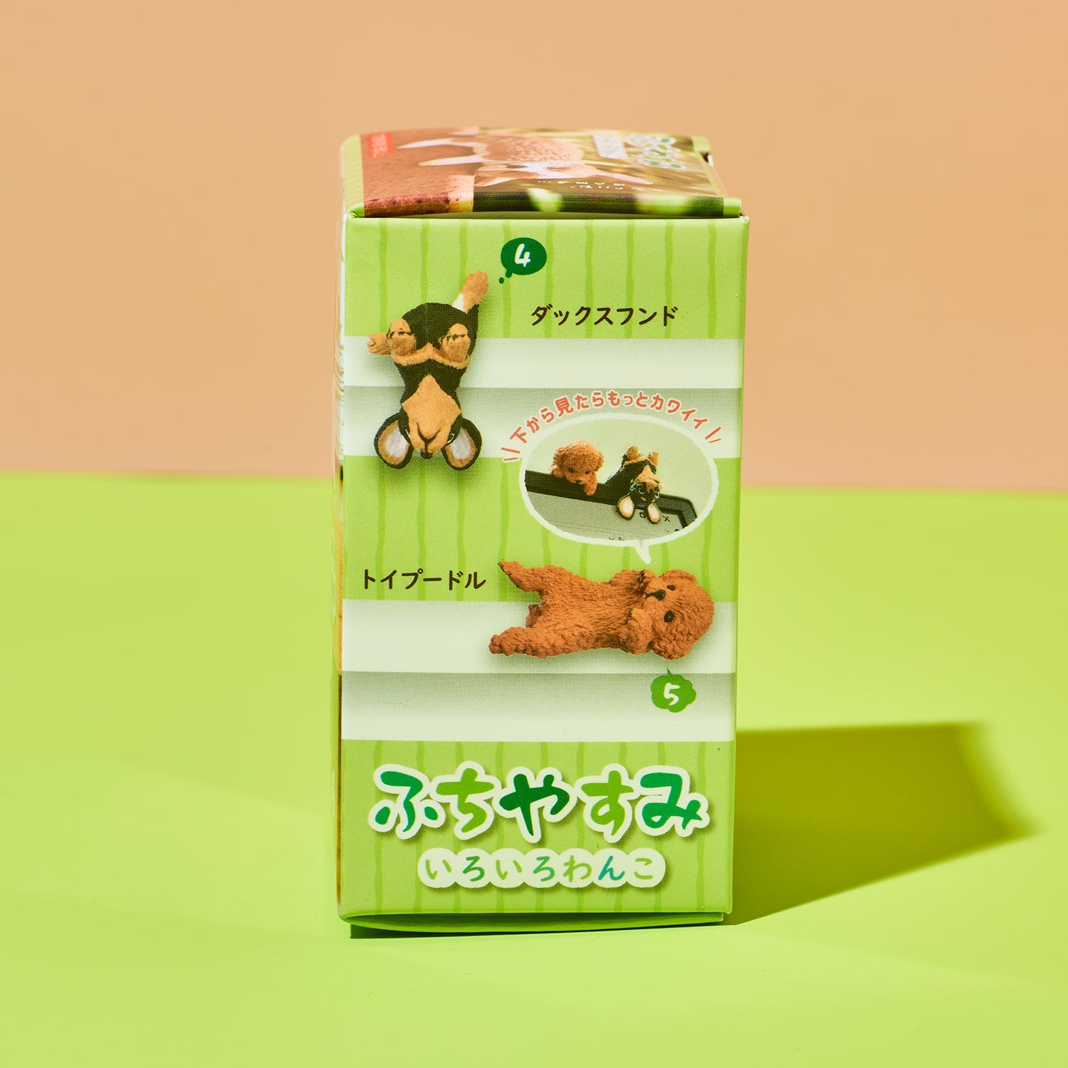 Green toy packaging with a small brown dog figure on a green and beige background