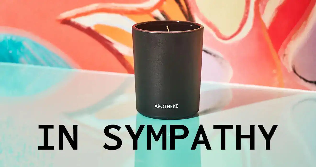 Black cylindrical candle with ’IN SYMPATHY’ text displayed below it.