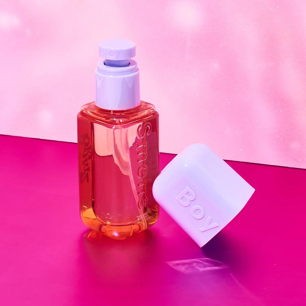 Bottle of perfume with a white cap on a pink background