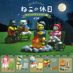 cartoon cats around a campfire with camping gear on a starry night background.