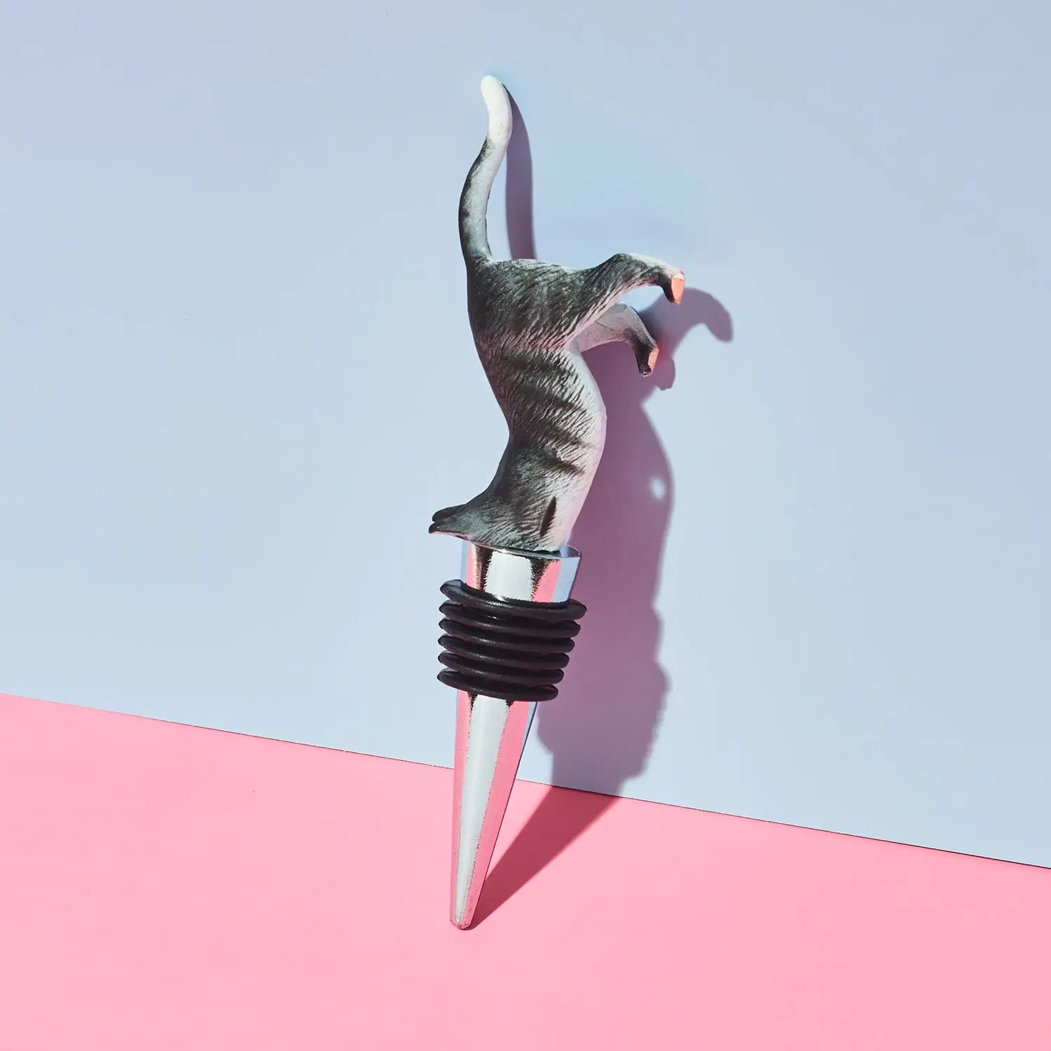 Cat-shaped bottle stopper on a pink and blue background
