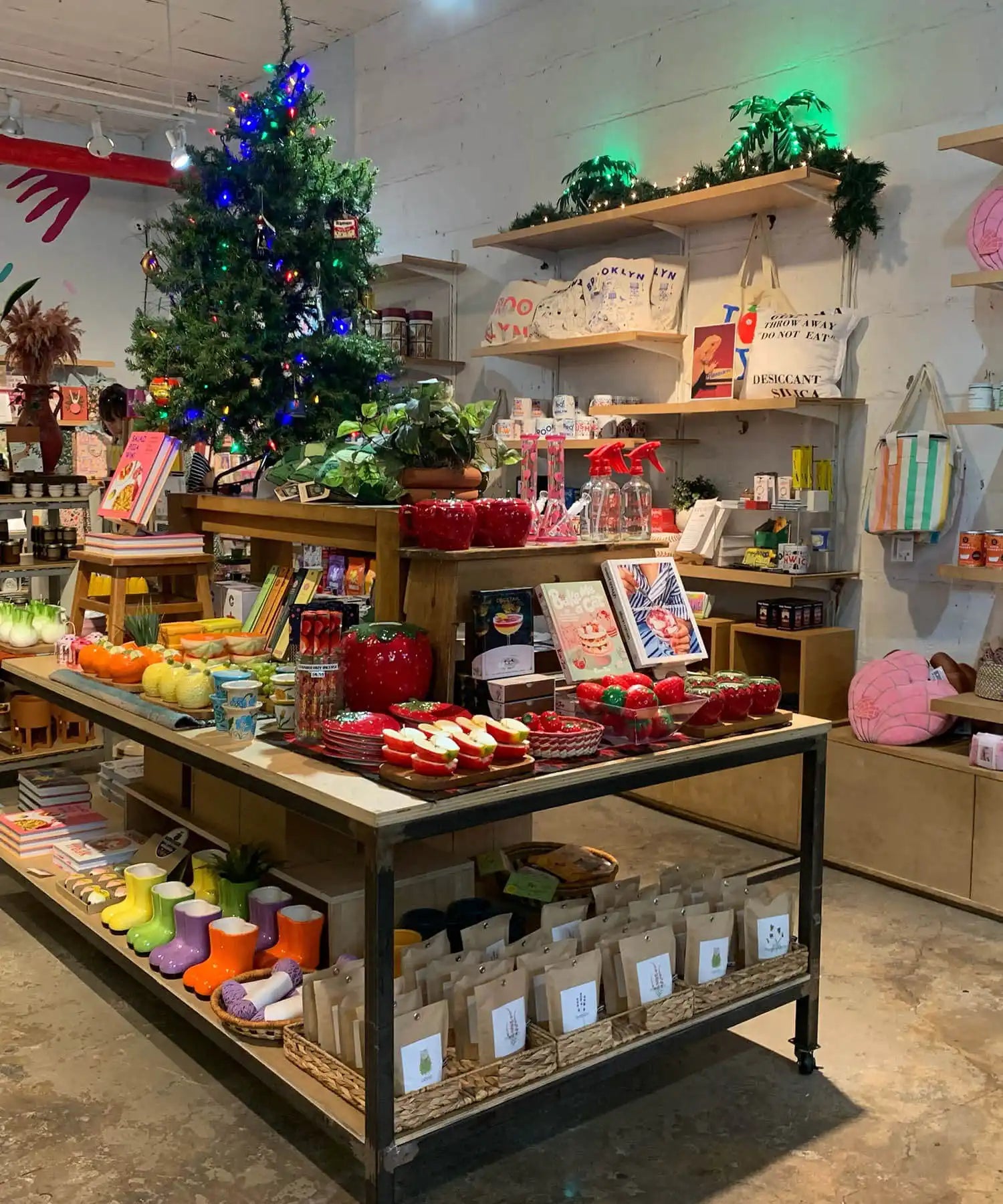 Display table with holiday merchandise and a decorated Christmas tree.