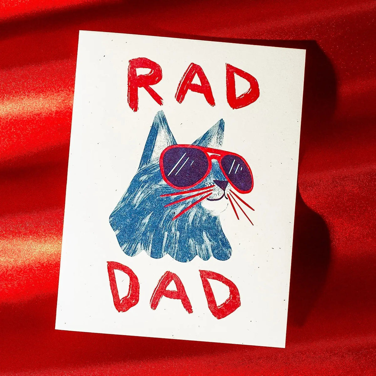 Card with a blue cat wearing sunglasses and 'RAD DAD' text on a red background