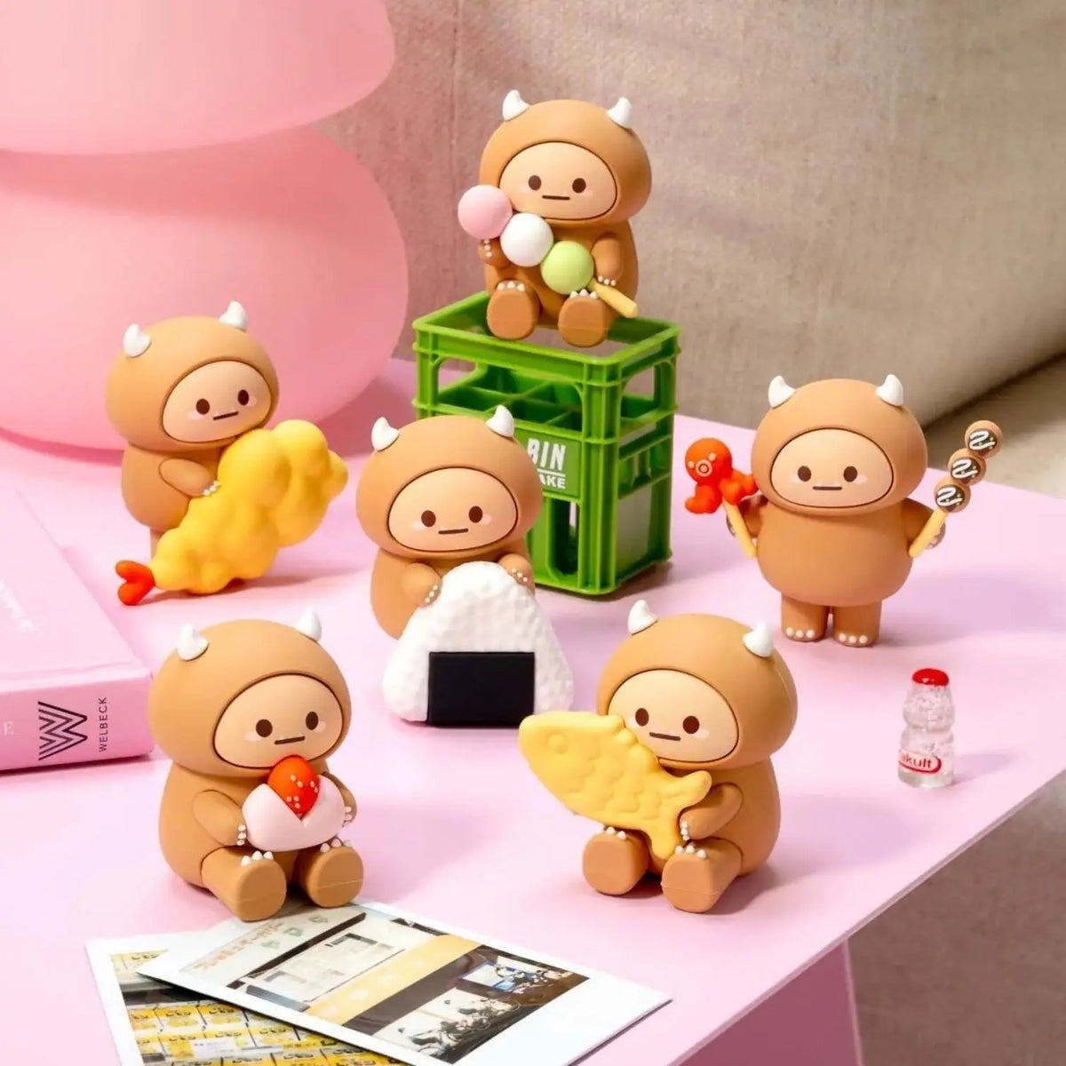 Set of cute brown animal figurines on a pink surface with a pink lamp in the background.