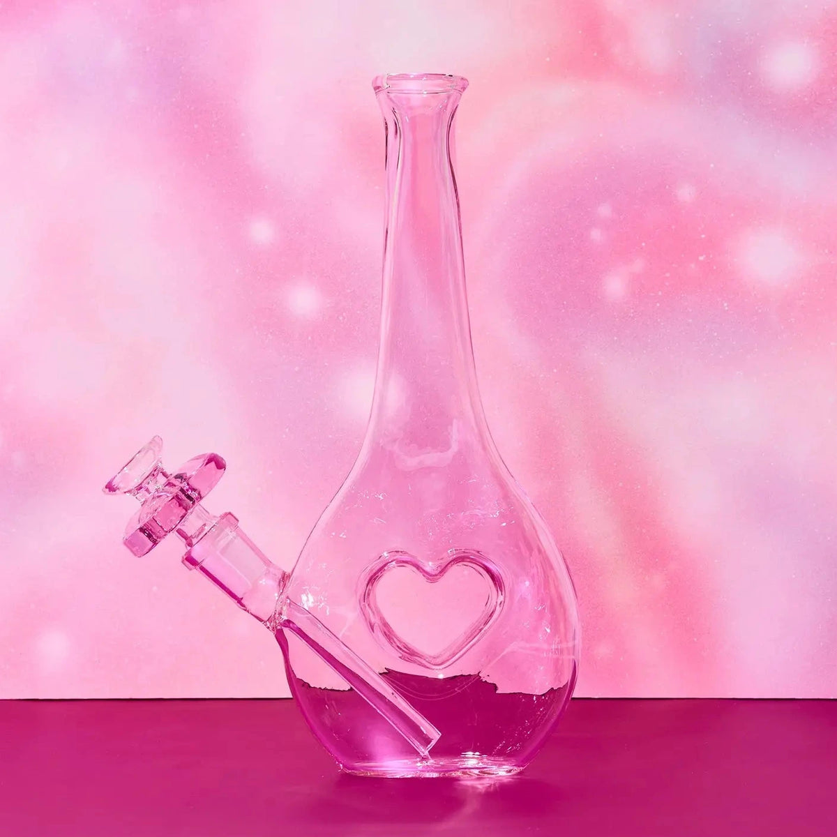 Glass water pipe with heart design on a pink and purple gradient background