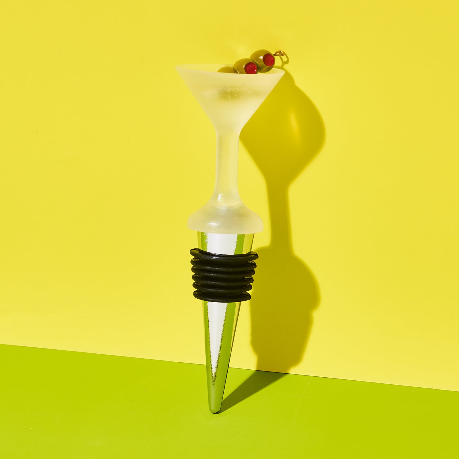 Wine bottle stopper with martini-shaped top on a yellow background