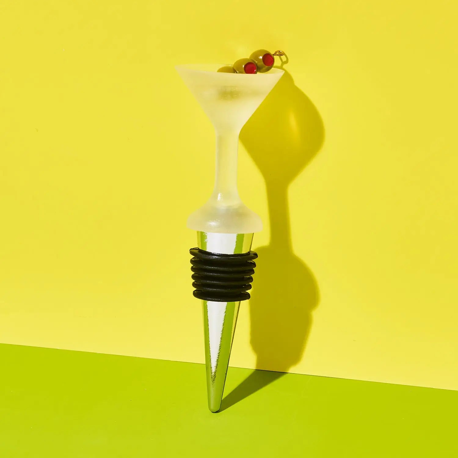 Wine bottle stopper with martini-shaped top on a yellow background