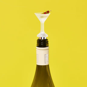Wine bottle with a novelty bottle stopper shaped like a cocktail glass on a yellow background