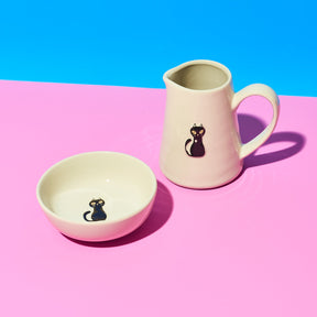Ceramic mug and bowl with cat design on a pink and blue background