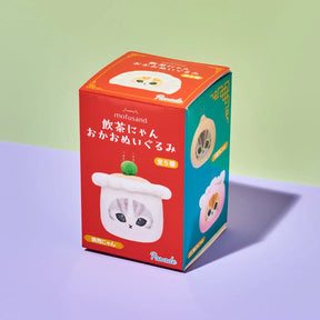 A red and teal box of mofusand 'Oka-Oka Omeyagari Mi' blind box figures, featuring cute cartoon illustrations of a cat and a dumpling on a split green and purple background.