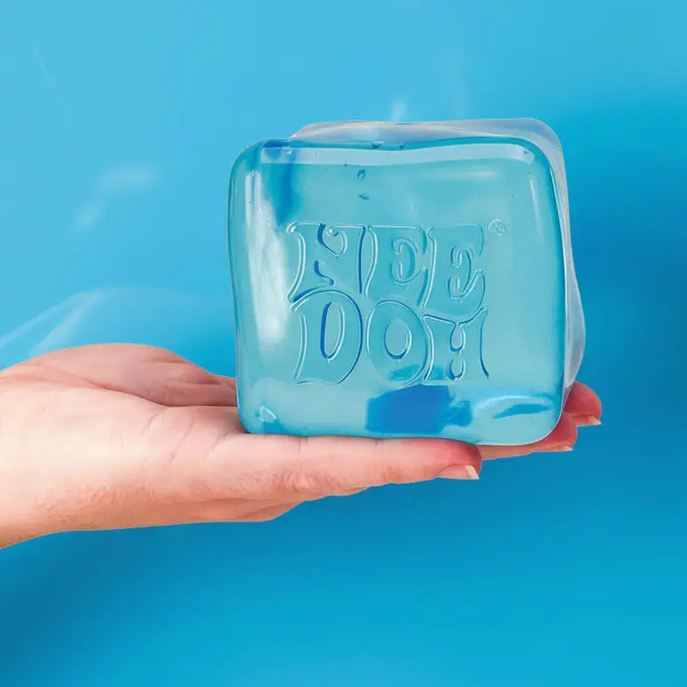Blue ice cube toy held in a hand against a light blue background