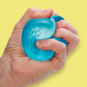 Hand holding a blue stress ball against a yellow background
