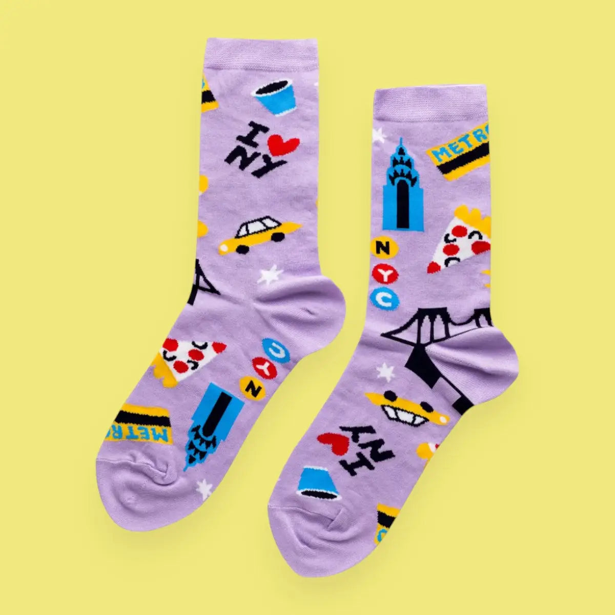 Pair of purple socks with colorful designs on a yellow background