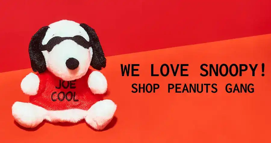 Plush Snoopy toy wearing a ’Joe Cool’ shirt against a red backdrop.