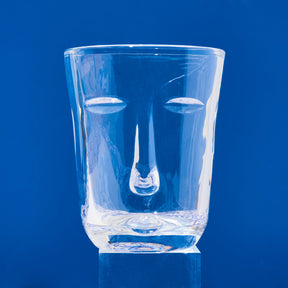 Clear glass with face design on a blue background