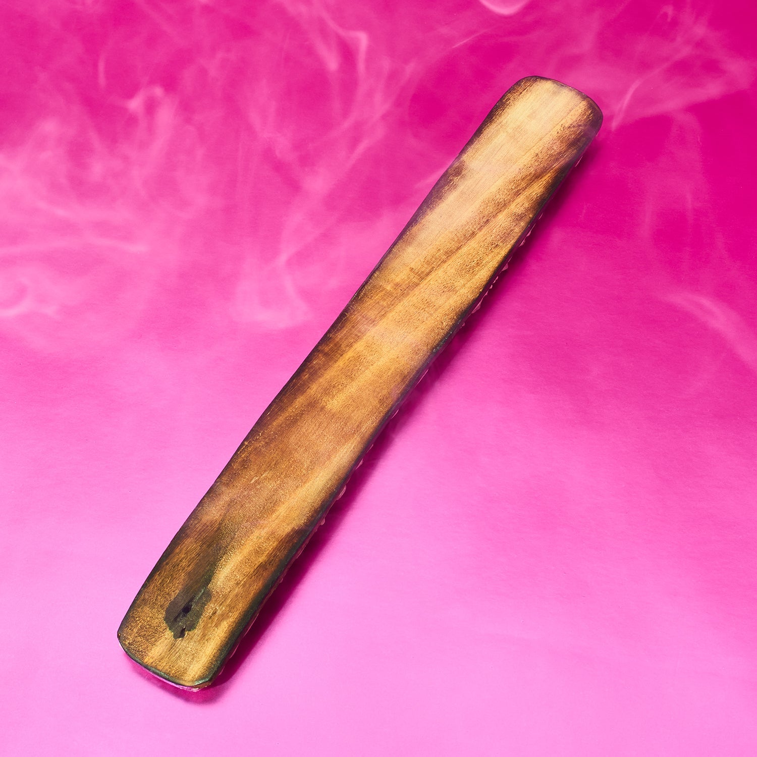 Wooden object on a pink background with smoke effect
