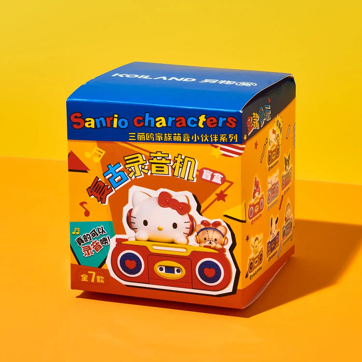 A Sanrio Hello Kitty character blind box packaging on a bright yellow and orange gradient background. The box features Sanrio characters including Hello Kitty and a bear in a red vintage radio design, with 'Sanrio characters' printed on the front.