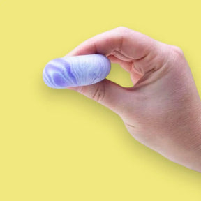 Hand holding a marbled purple and blue object against a yellow background