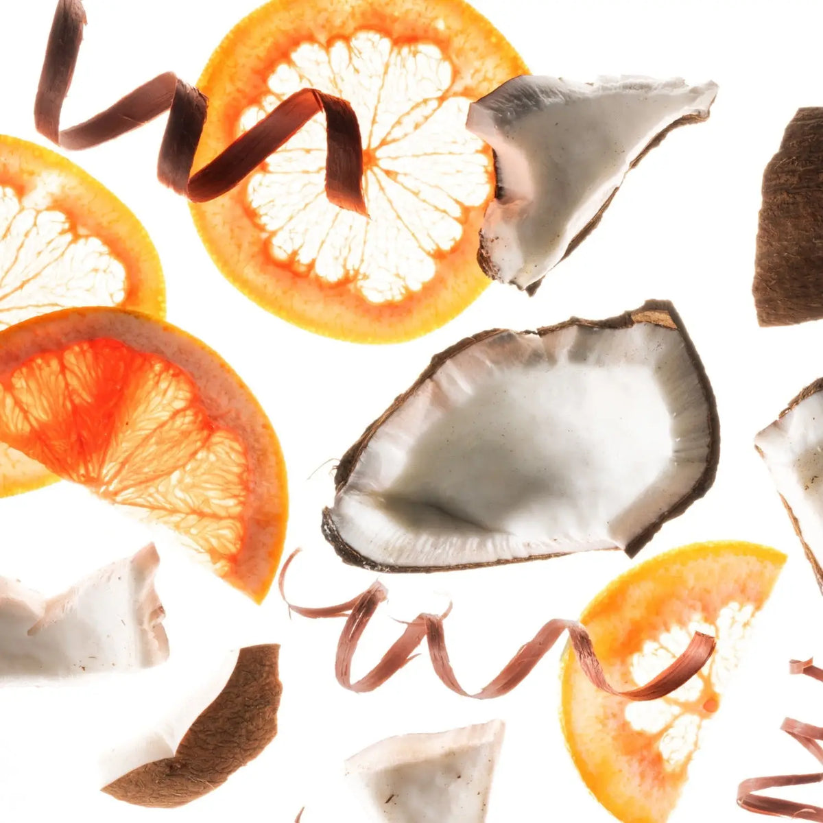 Sliced oranges and coconut pieces on a white background