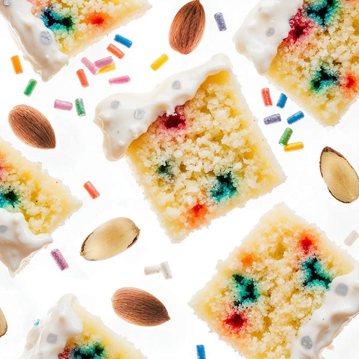 Colorful cake slices with sprinkles and almonds on a white background