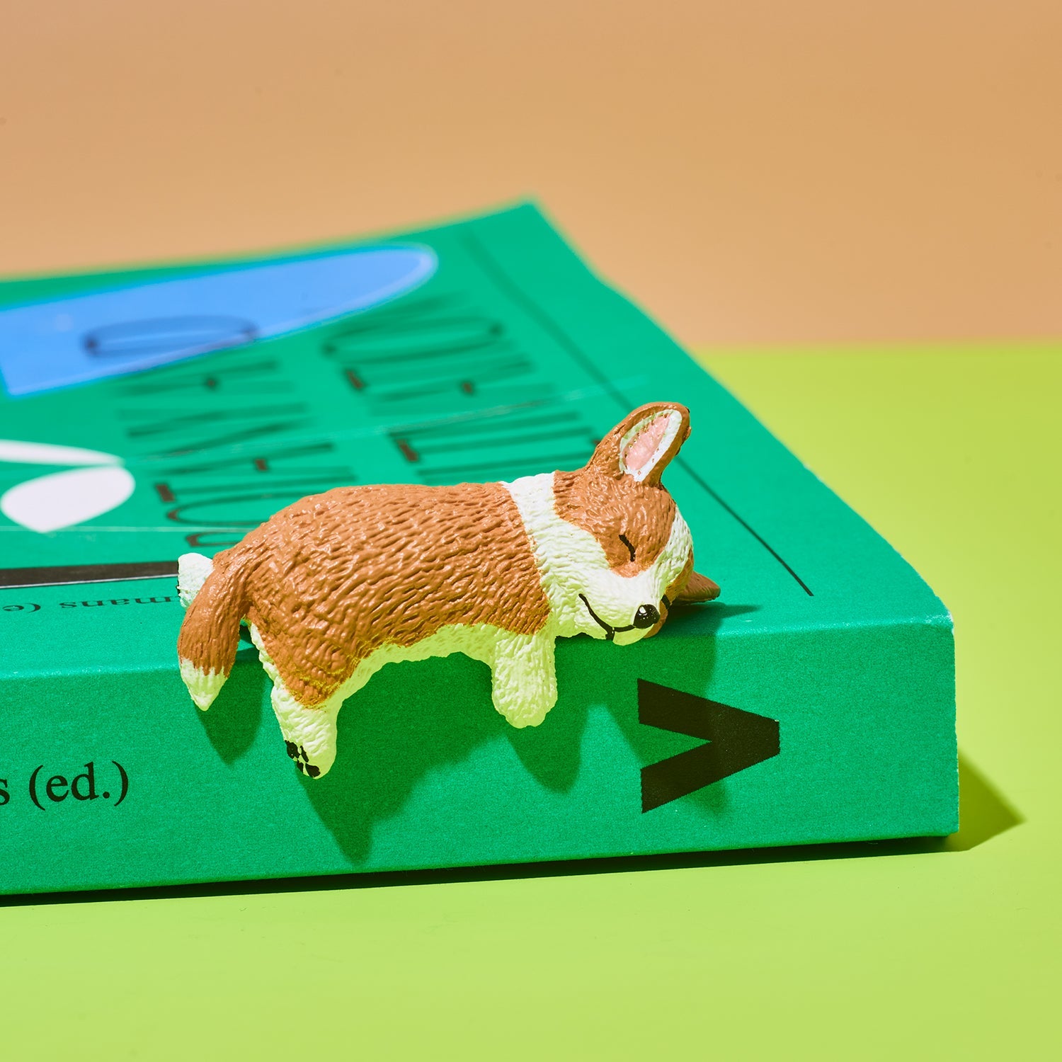 Small dog figurine on a green book with a brown background