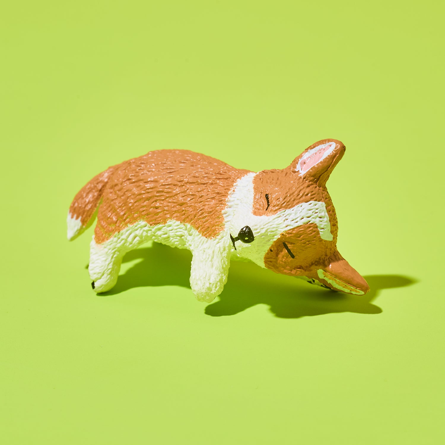 Toy figure of a corgi on a green background