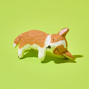 Toy figure of a corgi on a green background